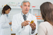 Photo d'un pharmacien qui conseille sa cliente une mutuelle santé pour angine poitrine