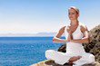 image d'une femme faisant du yoga pour preserver sa sante au bord de la mer