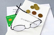 image avec une carte vitale, une ordonnance, des pièces de monnaie et des lunettes
