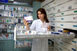 image d'une pharmacienne lisant l'ordonnance d'une patiente et regardant le médicament corespondant