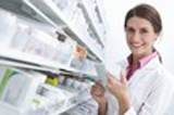 Photo représentant une pharmacienne souriante tenant une carte assurance mutuelle santé
